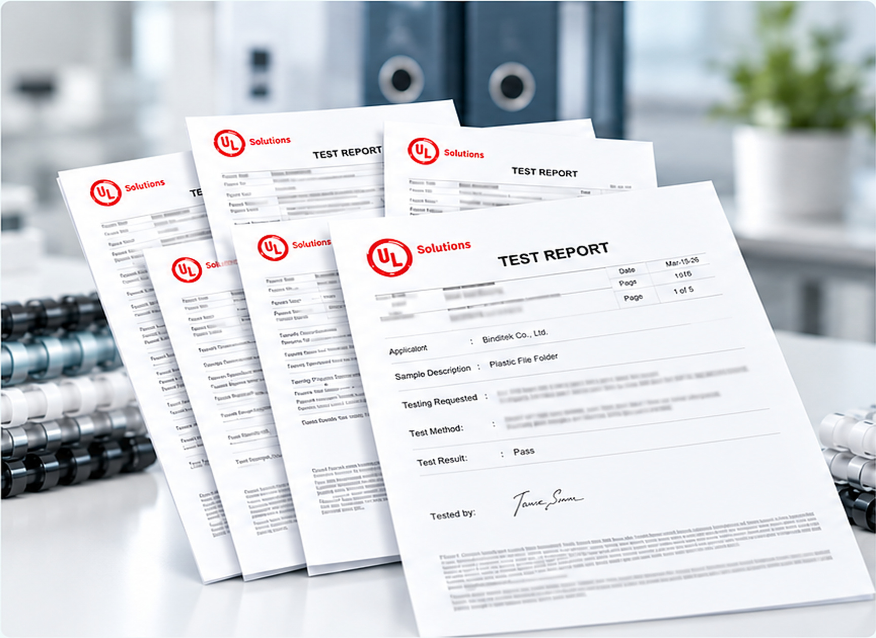 Test report sheets on a laboratory workbench with binding materials.